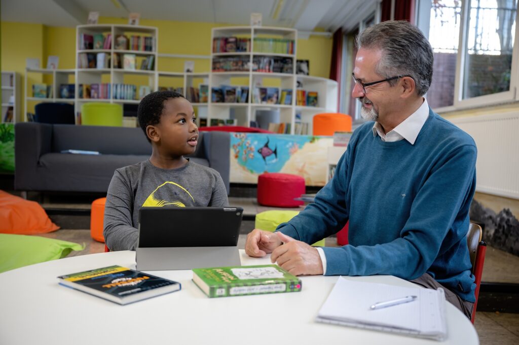 Ein Junge und ein Mann an einem Tisch, vor ihnen ein Tablet